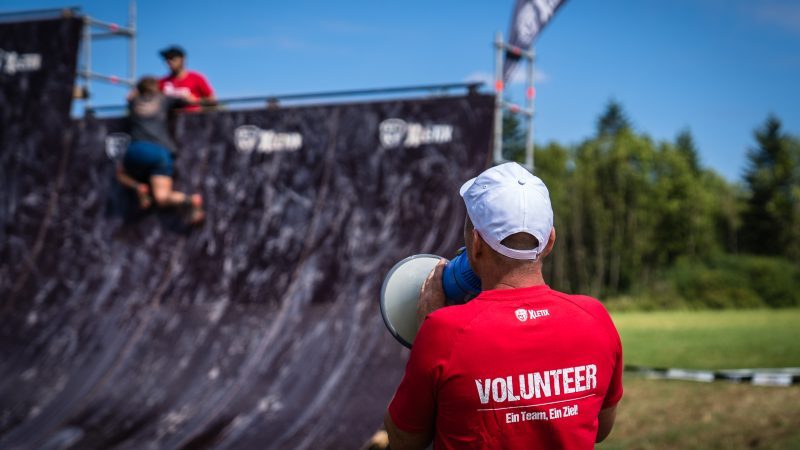 Volunteer mit Megafon am Hindernis